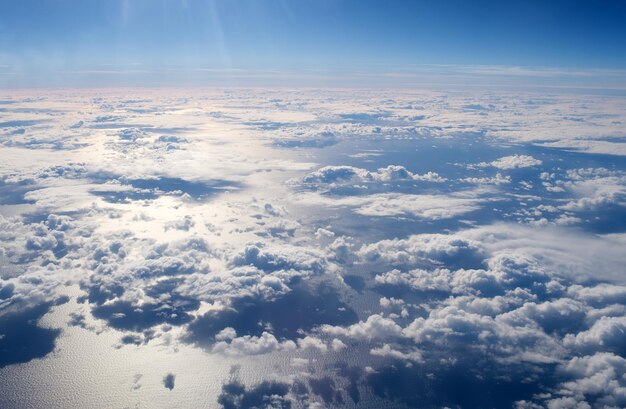 Vista desde la ventana del avión. Nubes sobre la superficie del agua. Concepto de atmósfera. La contaminación del aire. Efecto invernadero. Previsión meteorológica para días nublados. Viajar por aire. Libertad y belleza deslumbrante. Alto en el aire.