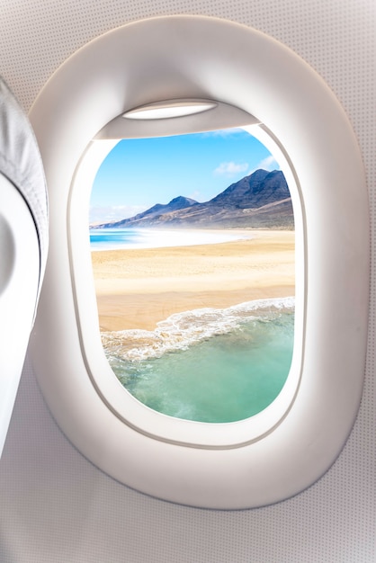 Vista desde la ventana de un avión de una playa paradisíaca.