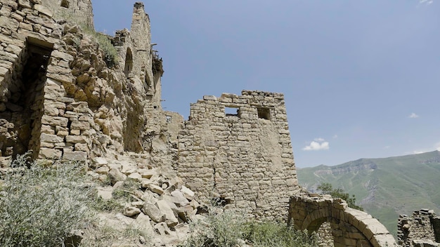 Foto vista de verano de edificios de piedra en ruinas abandonados en las montañas concepto de acción de la historia y la antigüedad