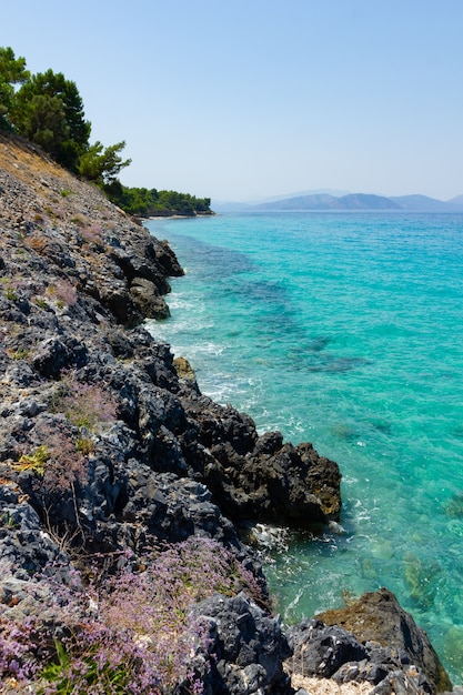 Vista vertical de la costa rocosa y agua de mar turquesa. Paisaje marino con montañas. Concepto de vacaciones de verano junto al mar.