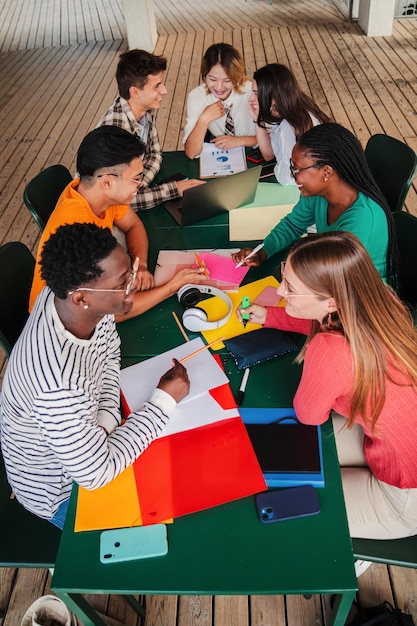 Foto vista vertical de alto ângulo de um grande grupo de estudantes adolescentes multirraciais trabalhando na universidade