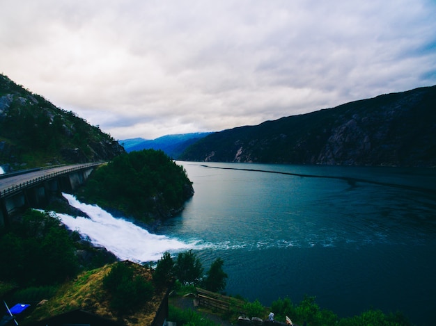 Foto vista vibrante de verano hermoso en el famoso lugar turístico noruego - trolltunga, la lengua trolls con un lago y montañas, noruega, odda.