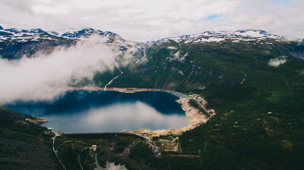 Foto vista vibrante de verano hermoso en el famoso lugar turístico noruego - trolltunga, la lengua trolls con un lago y montañas, noruega, odda.