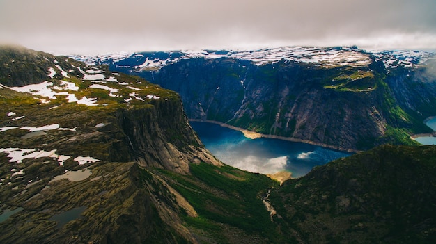 Vista vibrante de verano hermoso en el famoso lugar turístico noruego - trolltunga, la lengua trolls con un lago y montañas, Noruega, Odda.