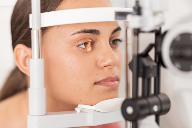 La vista de la vista y la mujer se someten a un examen ocular de oftalmología con luz en las pruebas de iris para ver la vista