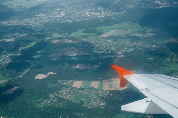 Vista desde el vuelo de la ventana en el aire con el ala de vuelo con un hermoso cielo azul y una nube