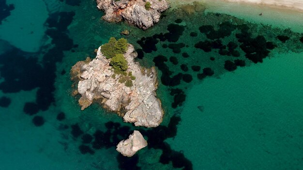 Foto vistas aéreas de drones sobre uma costa rochosa águas cristalinas do mar egeu praias turísticas e muita vegetação na ilha de skopelos grécia uma vista típica de muitas ilhas gregas semelhantes