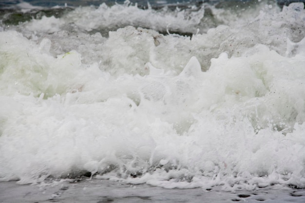 Foto vistas al mar directamente desde la playa, olas del mar y orilla arenosa