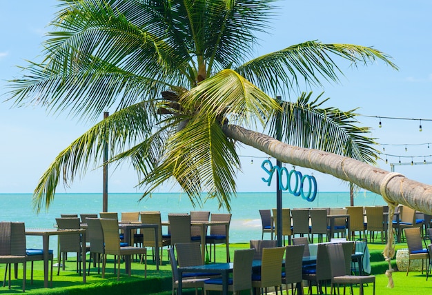 Vistas de los árboles de coco y de las mesas de comedor de la playa en Songkhla, Tailandia.