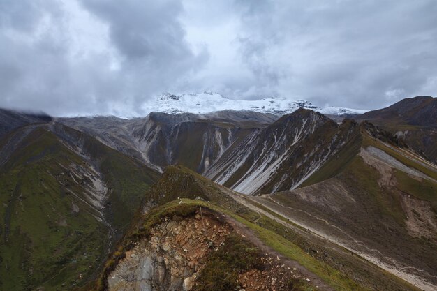 Vistas dos picos das montanhas cobertas de neve nas nuvens em Lantang