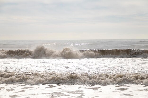 Vistas frontales de olas desde la playa. Un día nublado.