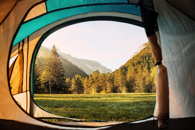 Vistas incríveis do vale e das montanhas de dentro de uma barraca durante o nascer do sol Camping férias de verão