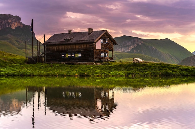 Vistas panorámicas al lago alpino alto y cabaña de madera