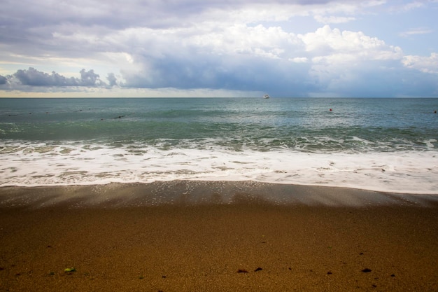 Vistas para o mar diretamente da praia, ondas do mar e costa arenosa