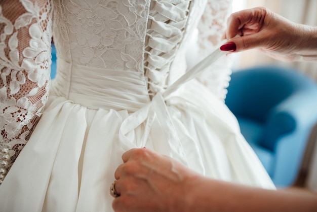 Foto viste a la novia con un vestido de novia con corsé y lazada