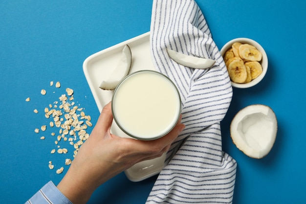 Foto visto desde arriba con un vaso de leche en la toalla de coco y plátanos en rebanadas sobre un fondo azul