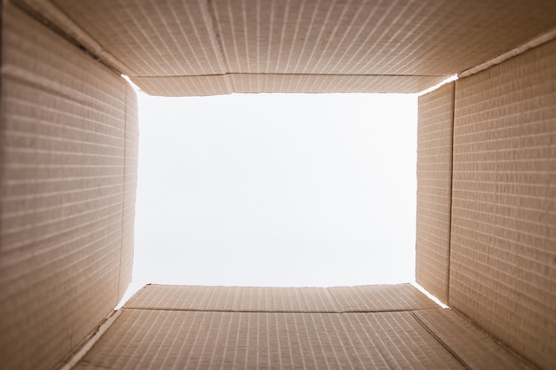 Visualização da caixa de papelão de dentro, papelão marrom, no branco Preparação para a mudança. Copie o espaço.