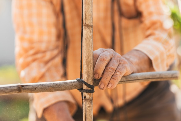 Visualização detalhada das mãos do homem trabalhando no campo