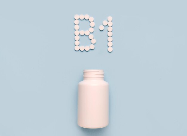 Vitamin B1 Thiamin-Symbol aus Tabletten und Medikamentenflasche auf blauem Hintergrund Sammlung von Vitaminen und Mineralstoffen