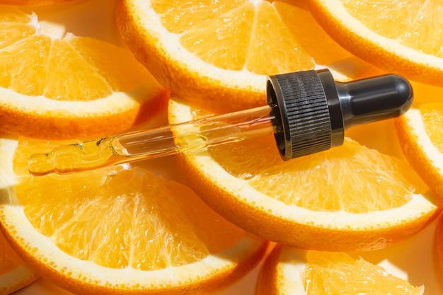 Vitamin-C-Serum-Extrakt in Tropfpipette mit geschnittenen Orangen Natürliche Hautpflege-Kosmetika