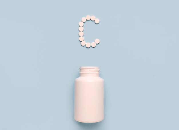 Vitamin C-Symbol aus Tabletten und Medikamentenflasche auf blauem Hintergrund Sammlung von Vitaminen und Mineralstoffen