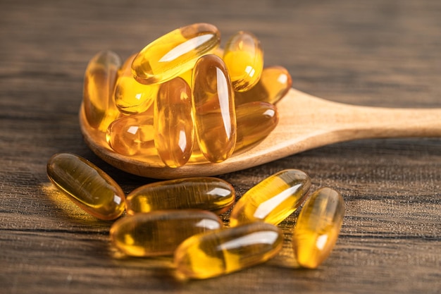 Vitamina de cápsulas de óleo de peixe Omega 3 com EPA e DHA isolado em fundo de madeira