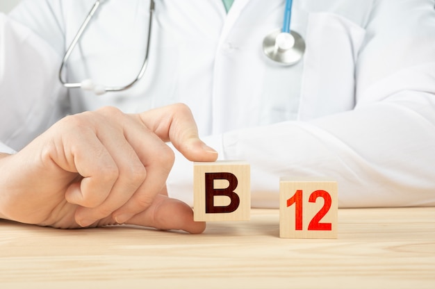 Vitaminas esenciales minerales para humanos Alfabeto B12 en cubo de madera médico recomienda vitamina B12