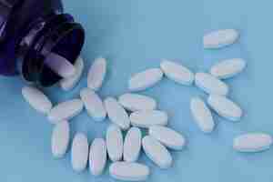 Foto vitaminas para fortalecer las articulaciones, glucosamina sobre un fondo azul claro.