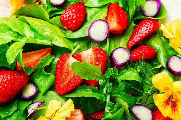 Vitaminsalat mit Erdbeeren, Spinat, Kapuzinerkresse und Rucola. Bunter Sommersalat. Lebensmittelhintergrund