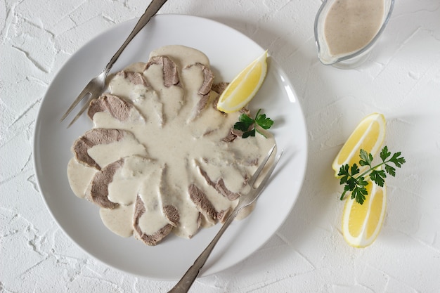 Vitello tonnato é um prato tradicional italiano sobre uma mesa branca.