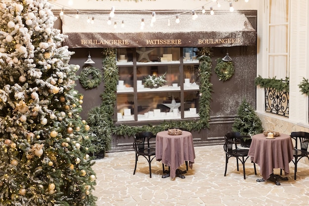 Vitrine de padaria de natal e decorações de natal árvore de natal com luzes perto do café da cidade com decorações festivas