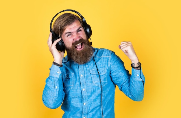 Vive tu pasión masculina en auriculares escucha música ebook y elearning concepto educación en línea curso de negocios en línea su canción favorita hombre alegre usa auriculares modernos