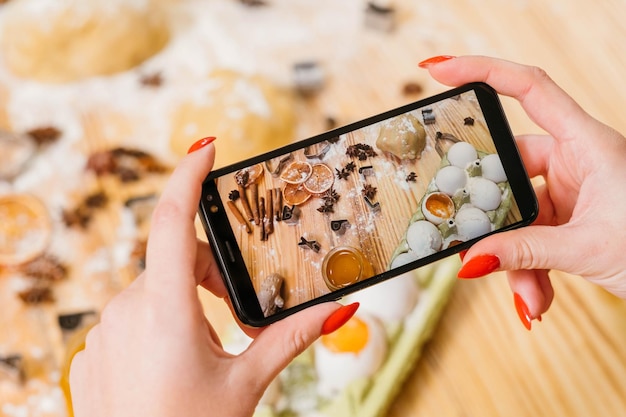 Vlog de confeitaria Senhora usando smartphone para gravar etapas de cozimento de biscoitos de gengibre Ingredientes na tela