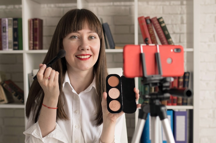 Foto vlogger de belleza femenina mostrando cosméticos