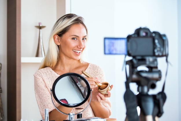 Vlogger de belleza profesional haciendo tutorial de maquillaje de transmisión en vivo