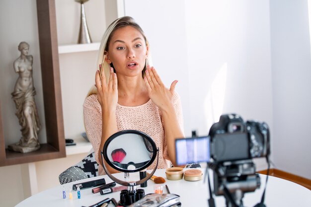 Vlogger de belleza profesional haciendo tutorial de maquillaje de transmisión en vivo