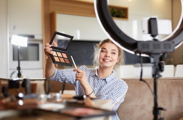 Vlogger femenina presentando video tutorial de maquillaje