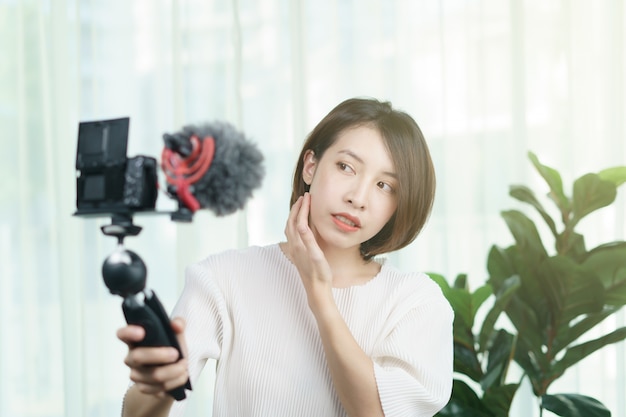 Vlogger femenino grabando con una cámara en casa