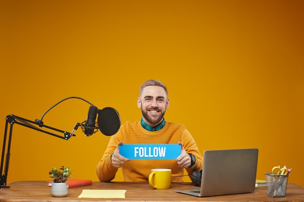 Vlogger Holding Follow Sign Plate