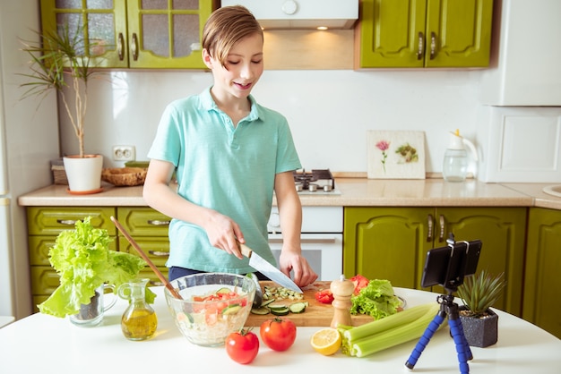 Vlogger infantil gravando receita de vegetais saudáveis blog de culinária para vegetarianos