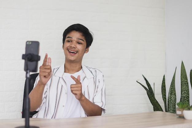 Vlogger usando uma câmera de telefone montada em um tripé para gravar seu vídeo Conceito de mídia social