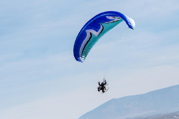 Voando com paramotor no ar no fundo do céu azul