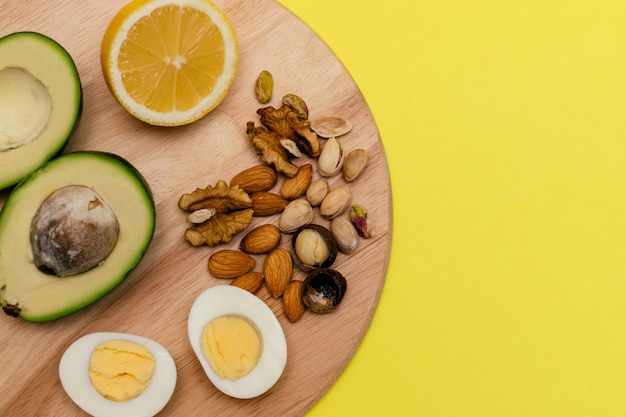 Foto Аvocadoeggslemonnuts sobre la tabla de cortar de madera