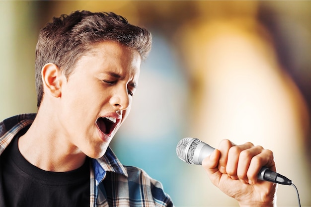 Vocalista principal masculino cantando en estudio con antecedentes de instrumentos musicales.