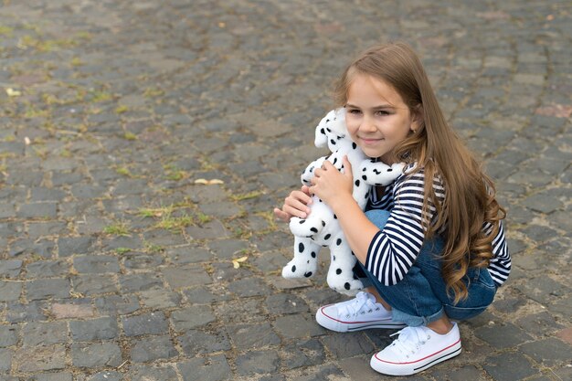 Você é meu amigo. Menina pequena brincar com cachorro de brinquedo ao ar livre. Criança gosta de amizade. Amizade de infância. Desenvolvimento de habilidades de comunicação. Dia internacional da amizade. Amor e confiança, copie o espaço.