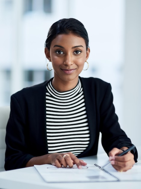 Você escreve sua própria história de sucesso nos negócios Retrato de uma jovem empresária atraente trabalhando e escrevendo notas em seu diário no trabalho