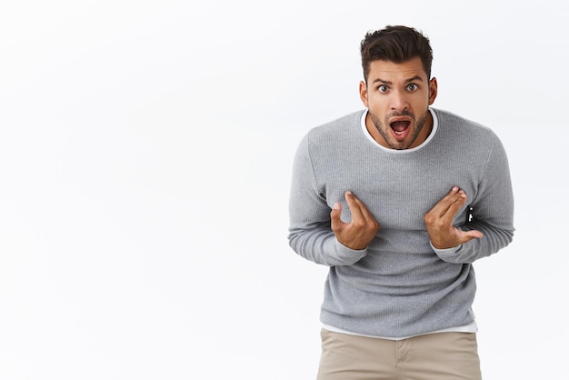 Você está falando comigo homem bonito com expressão de desagrado acusado apontando-se em pose curvada olhando chocado e frustrado chateado alguém quer dizer que é culpa sua raiva e emoções surpresas