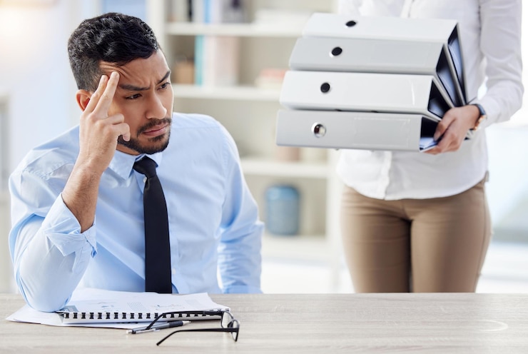 Foto você está me trazendo mais trabalho. foto de um jovem empresário olhando estressado no trabalho.