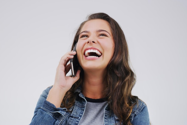 Você me faz rir toda vez que liga para o estúdio Foto de uma jovem usando um telefone celular contra um fundo cinza