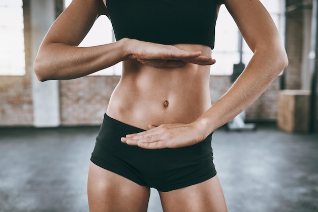 Você obtém exatamente para o que trabalha foto recortada de uma mulher emoldurando a barriga com as mãos